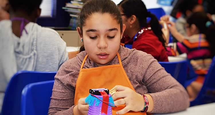 A young girl is focused on her craft at Elmcor Youth and Adult Activities in Queens, New York